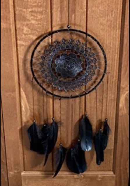 A black feather and metal circular wall hanging.