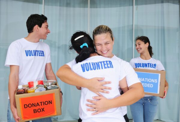 A group of people hugging and holding boxes.