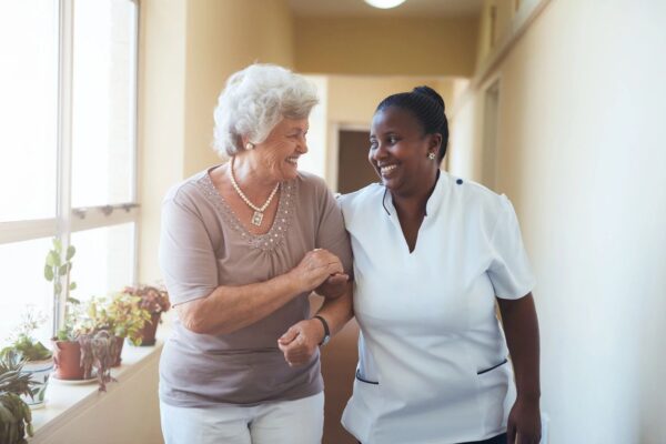 Two women are smiling and walking together.